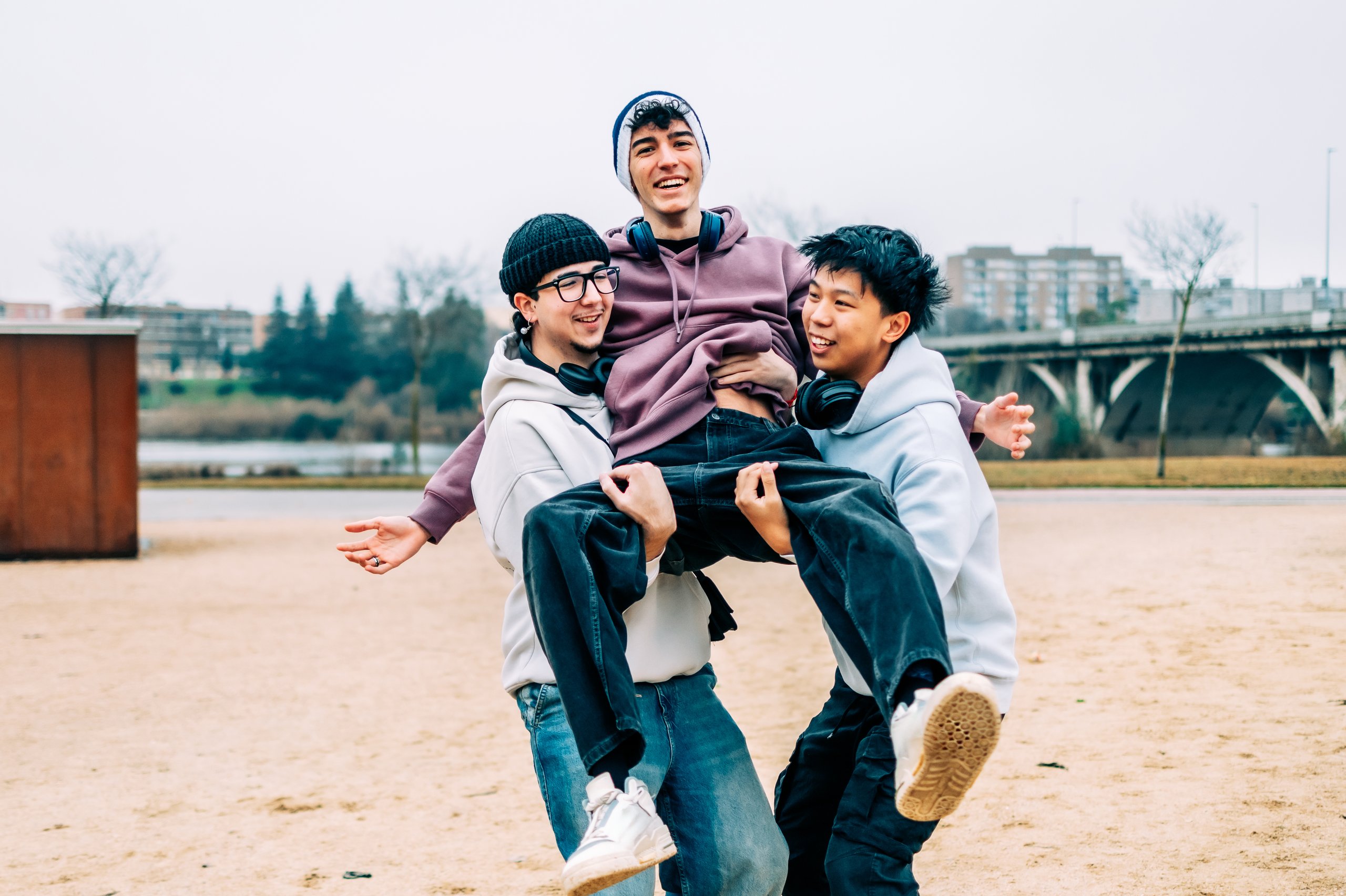Two happy young male friends laughing and having fun together outdoors, positive friendship and engagement