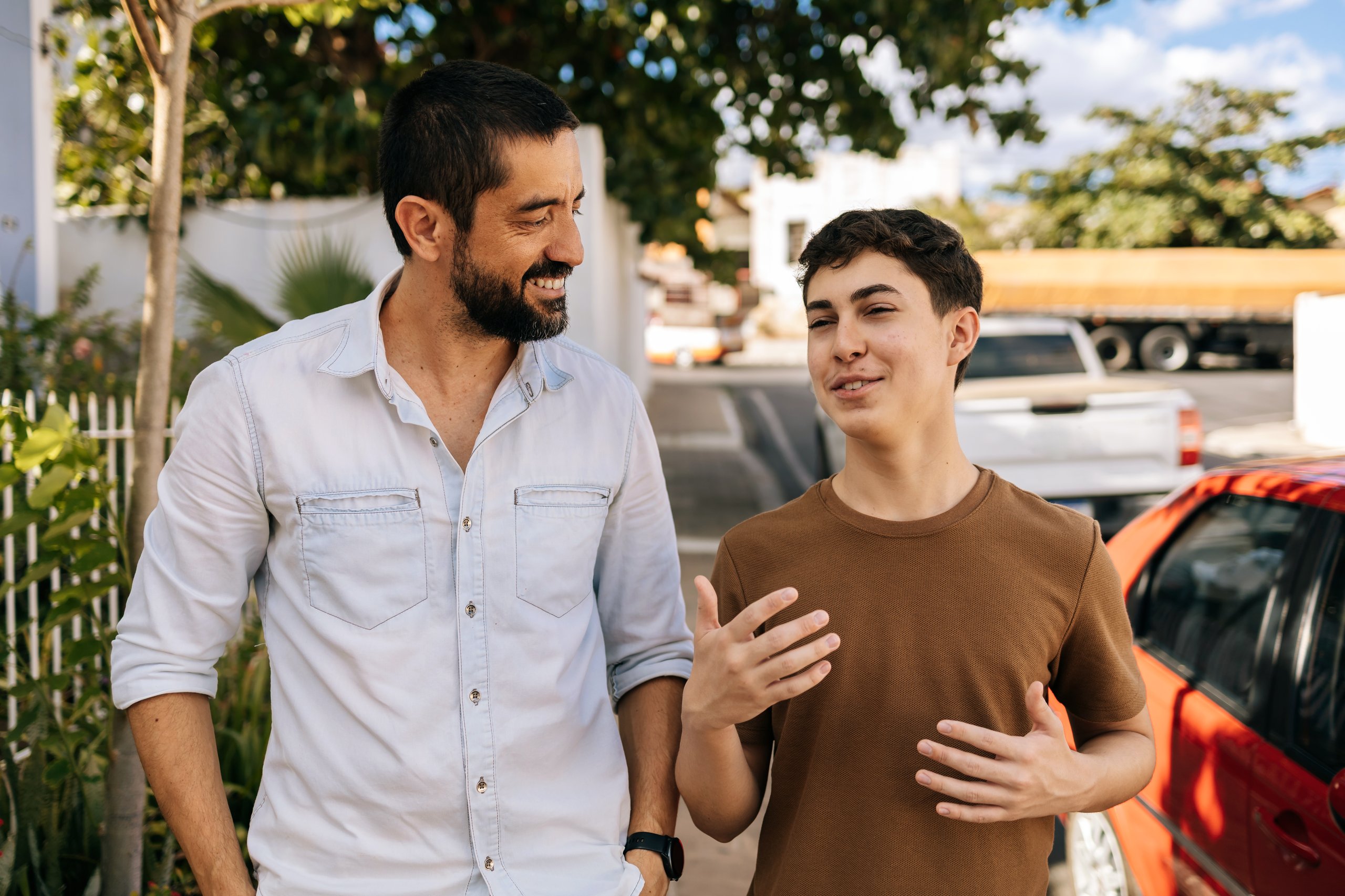 Teenage boy walking outdoors with father, supportive mentoring relationship and quality time